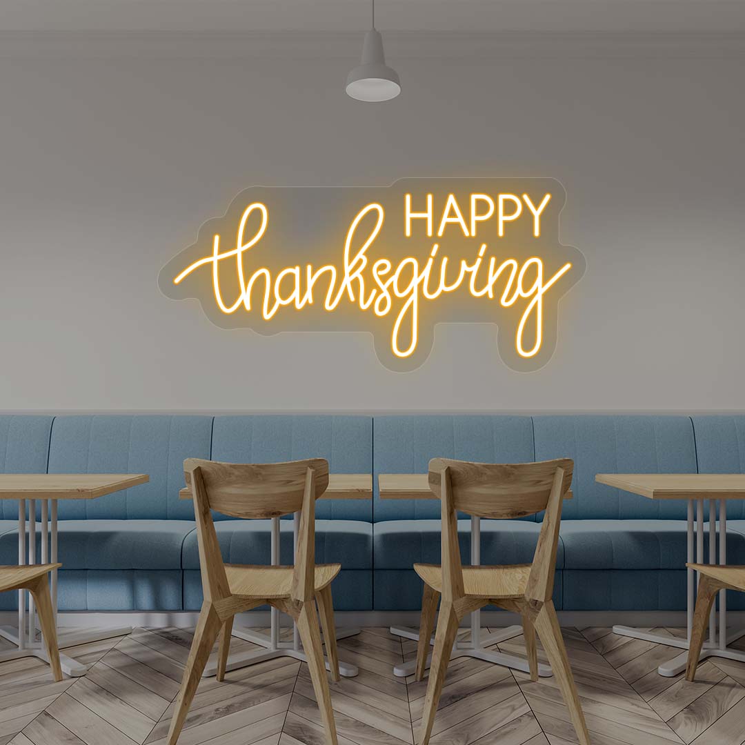 Happy Thanksgiving neon sign in orange script on cafe wall