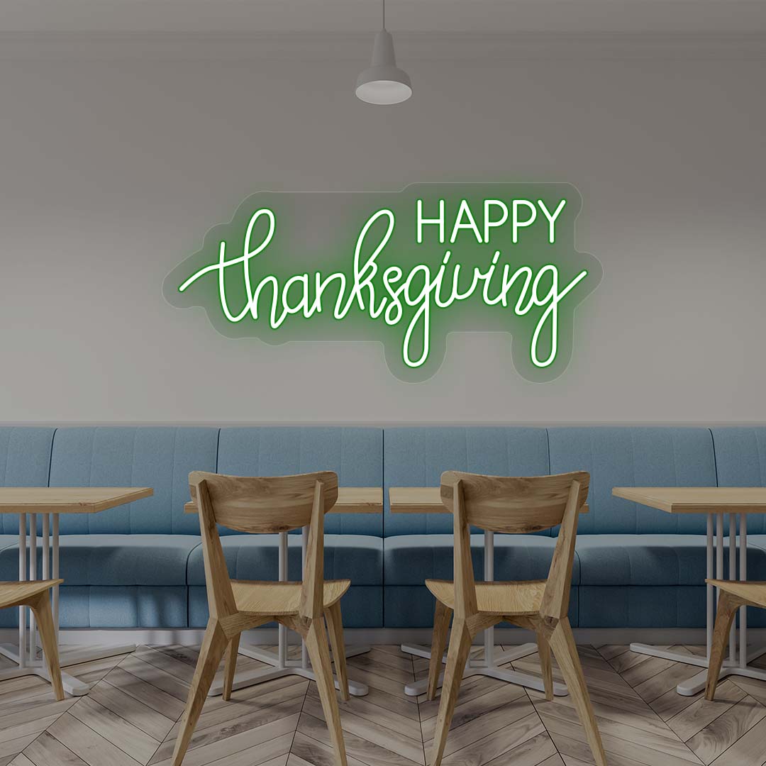 Happy Thanksgiving neon sign in green script on cafe wall