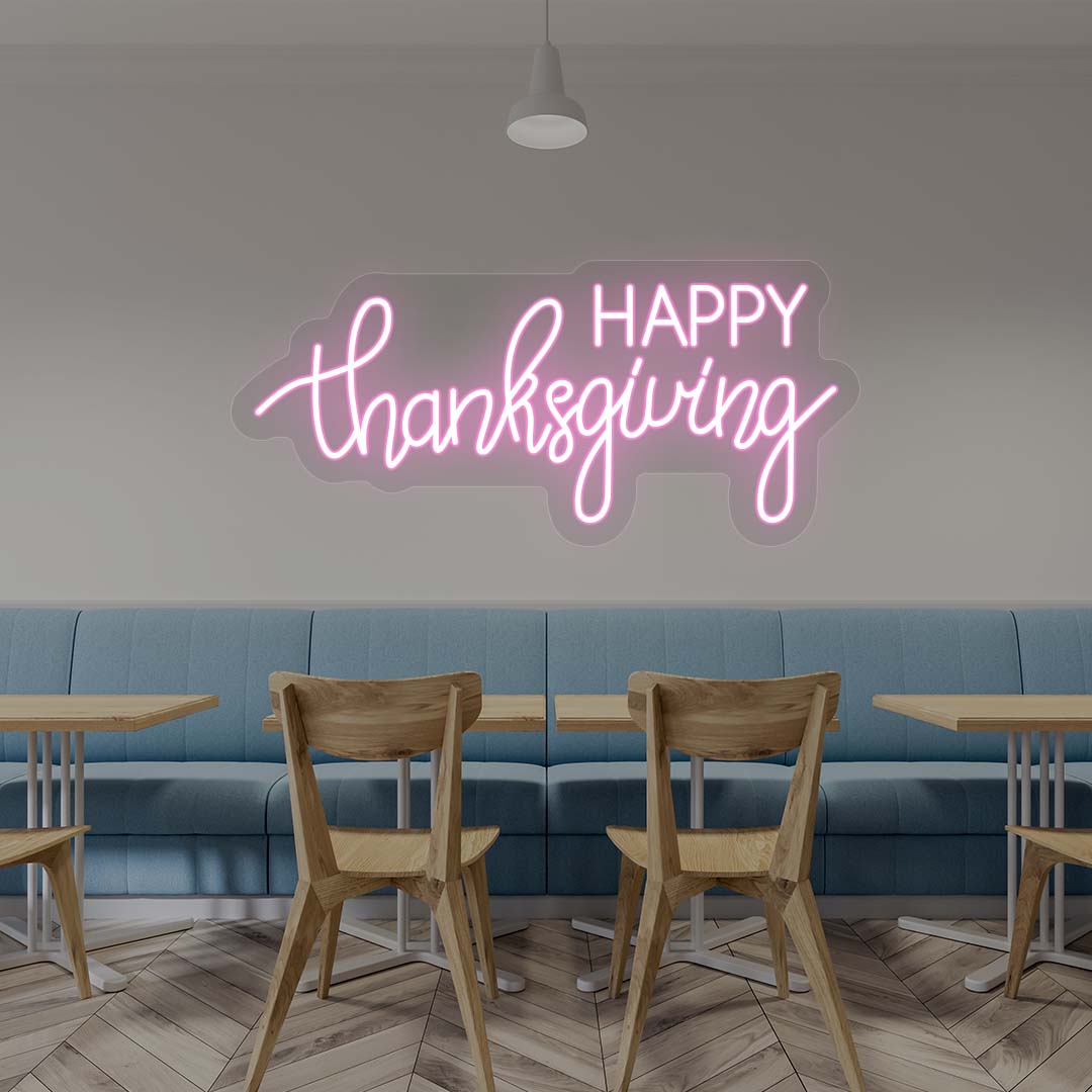 Happy Thanksgiving neon sign in pink script on cafe wall