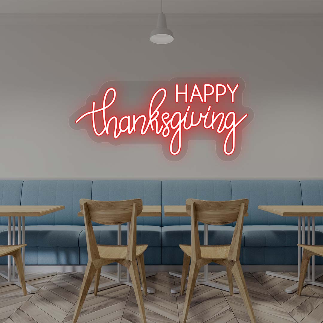 Happy Thanksgiving neon sign in red script on cafe wall