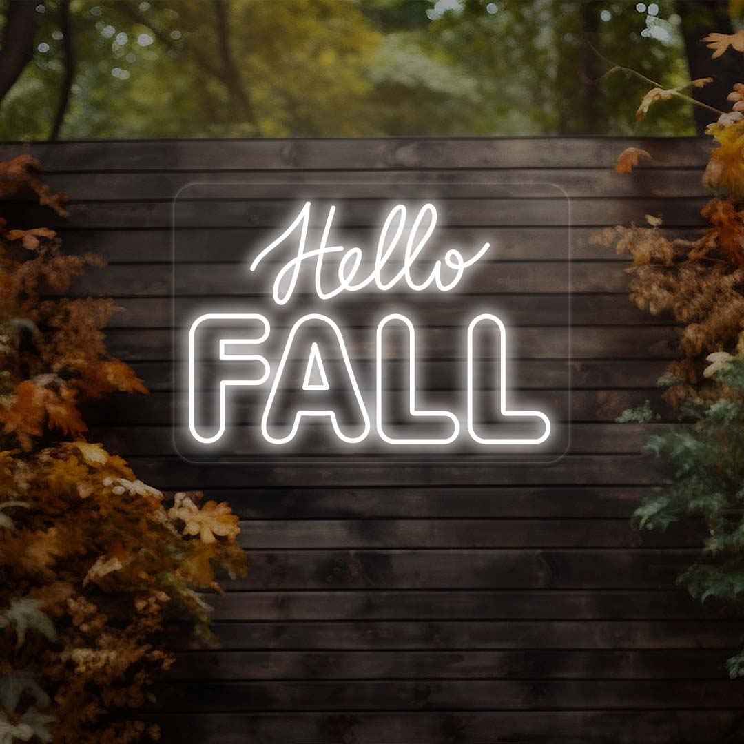 Hello Fall neon sign in white on dark wood outdoor wall with autumn leaves