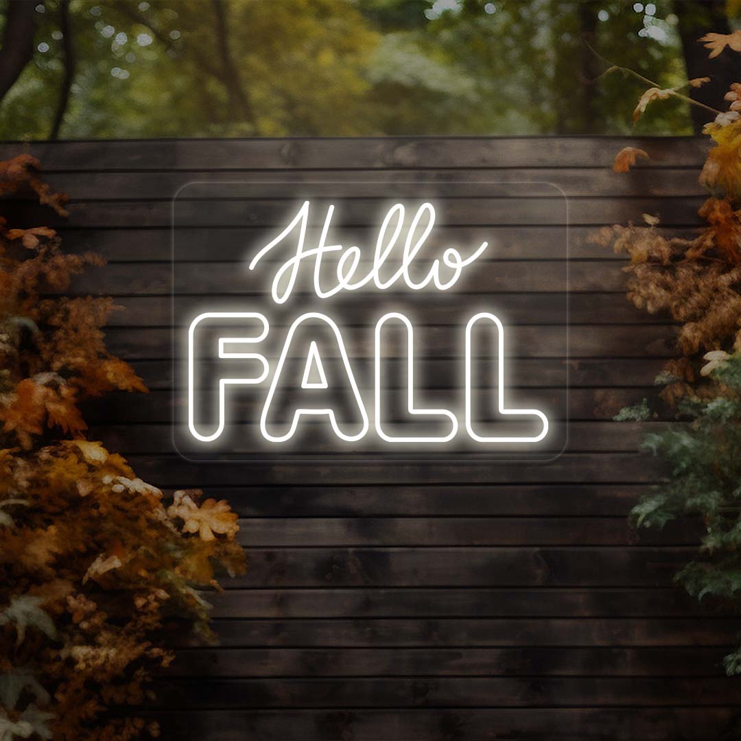 Hello Fall neon sign in white on dark wood outdoor wall with autumn leaves