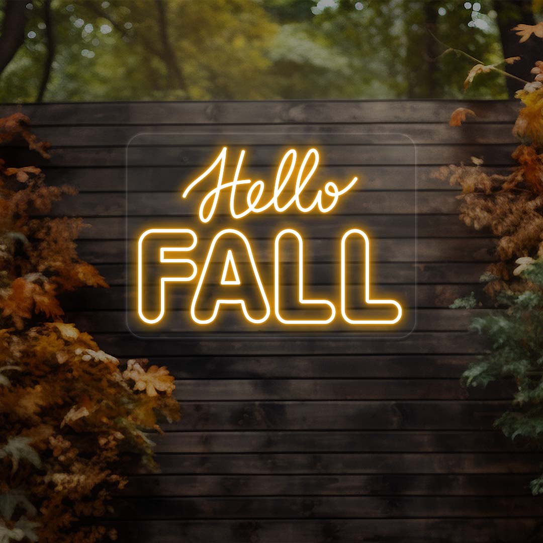 Hello Fall neon sign in orange on dark wood outdoor wall with autumn leaves