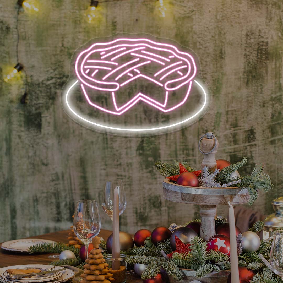Thanksgiving pie neon sign in bright pink above festive table with holiday ornaments and candles