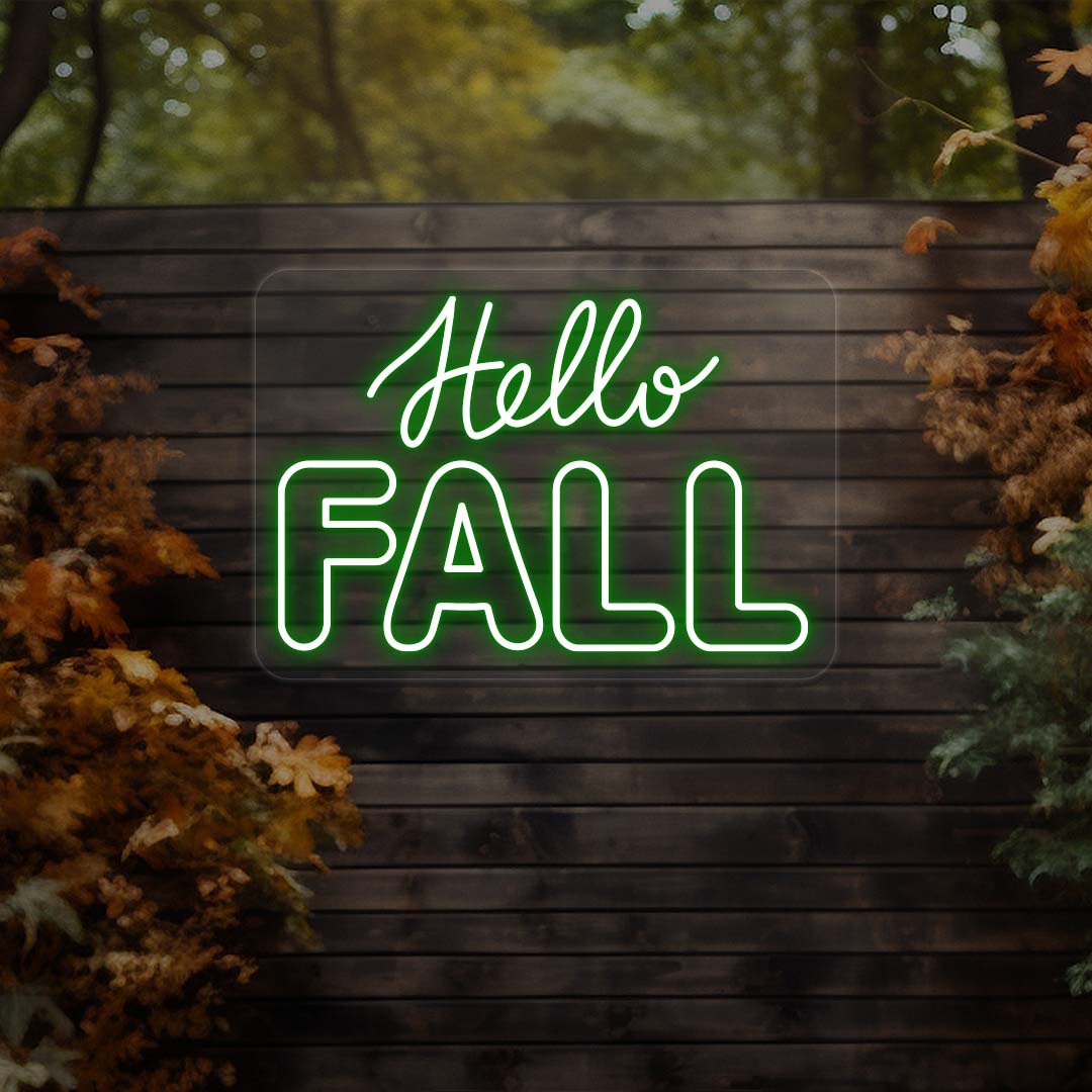 Hello Fall neon sign in green on dark wood outdoor wall with autumn leaves