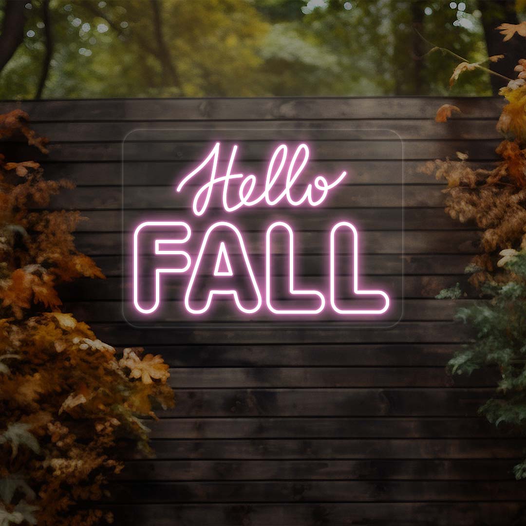 Hello Fall neon sign in pink on dark wood outdoor wall with autumn leaves