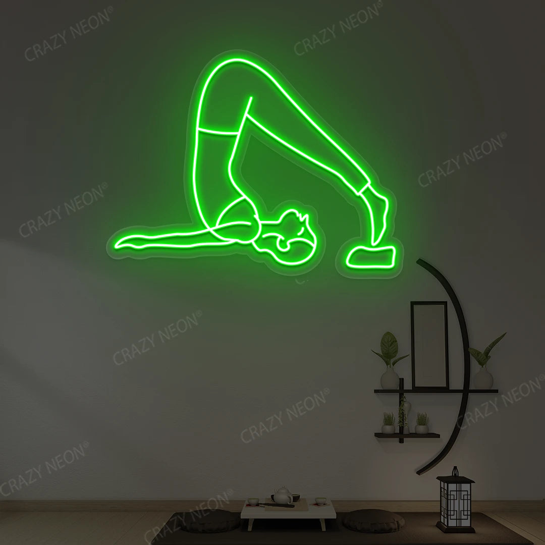 Halasana Yoga Neon Sign glowing in green color in a yoga room