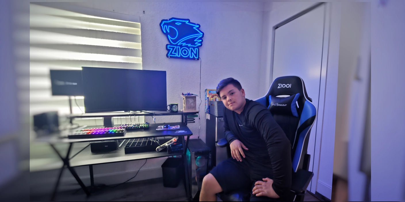 Zion gaming neon sign above RGB desk setup with boy in gaming chair