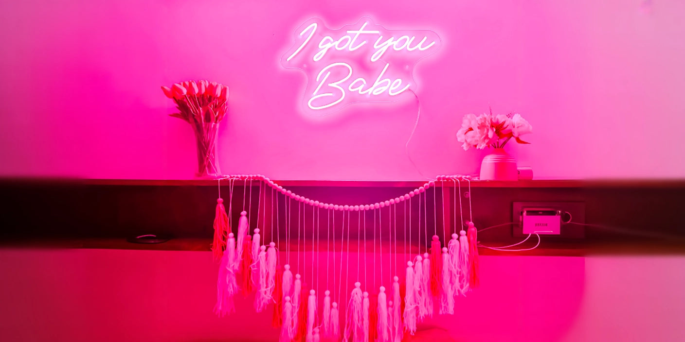 I Got You Babe pink neon sign glowing above shelf