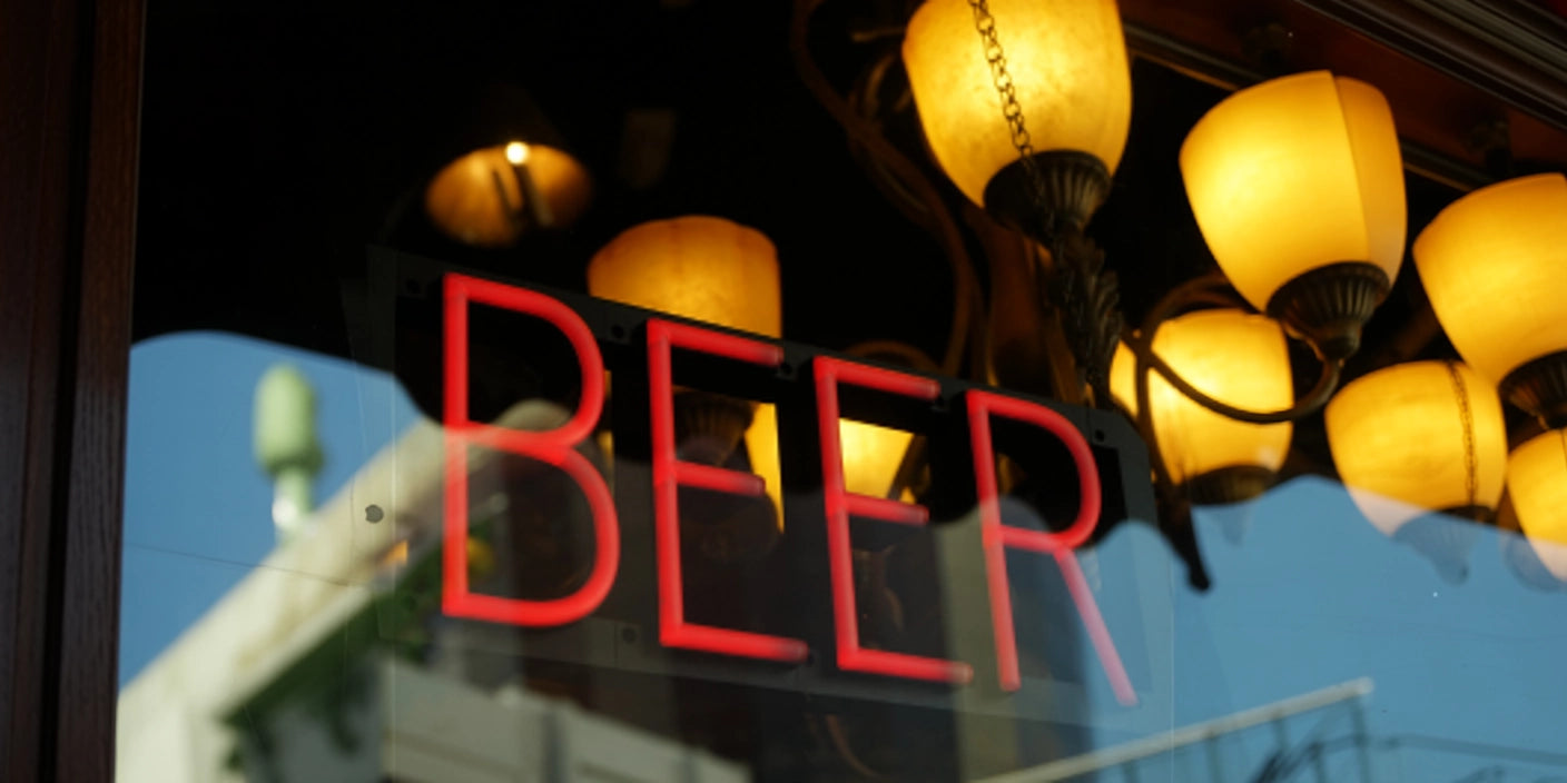 Red BEER neon sign glowing in bar window