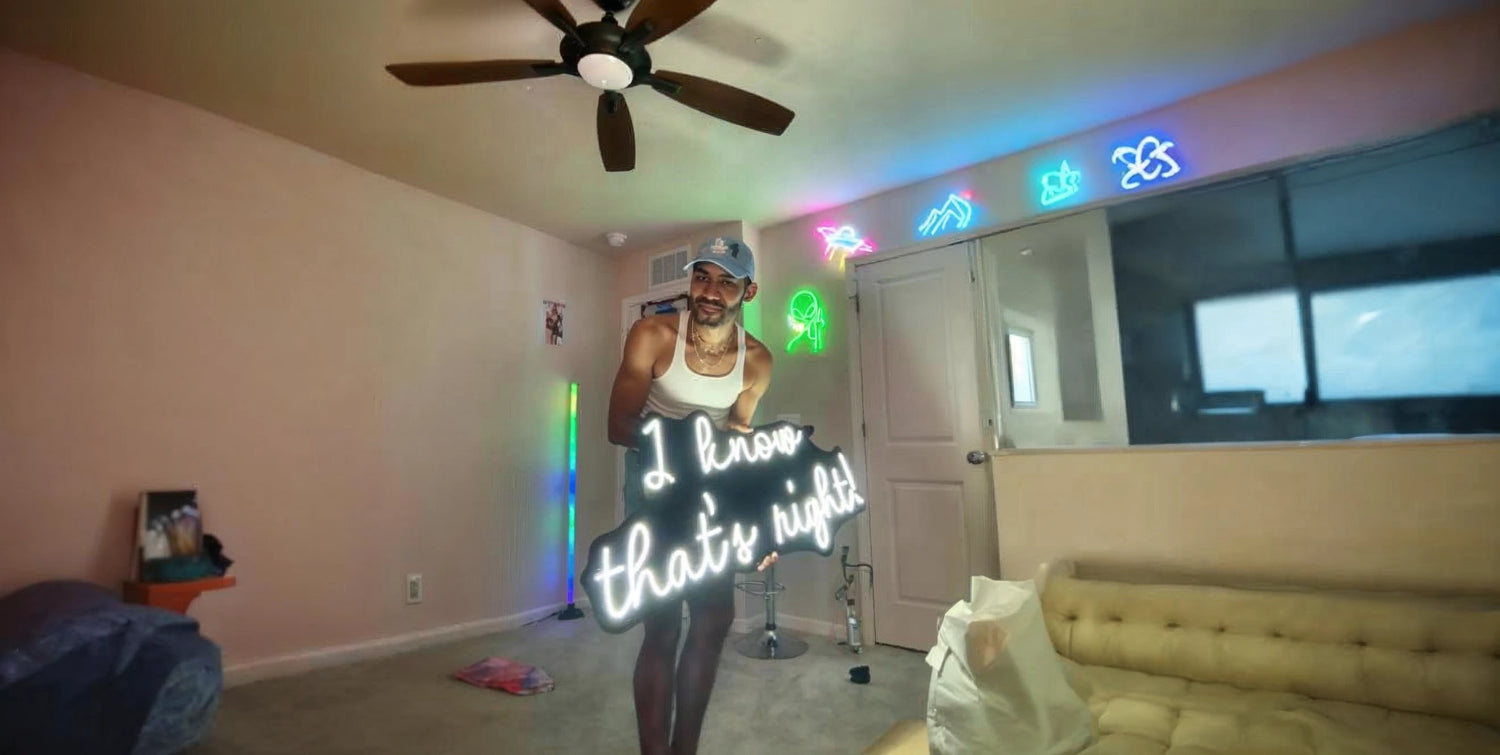 Man in white tank top and blue cap holding I know thats right neon sign in colorful room with wall neon lights