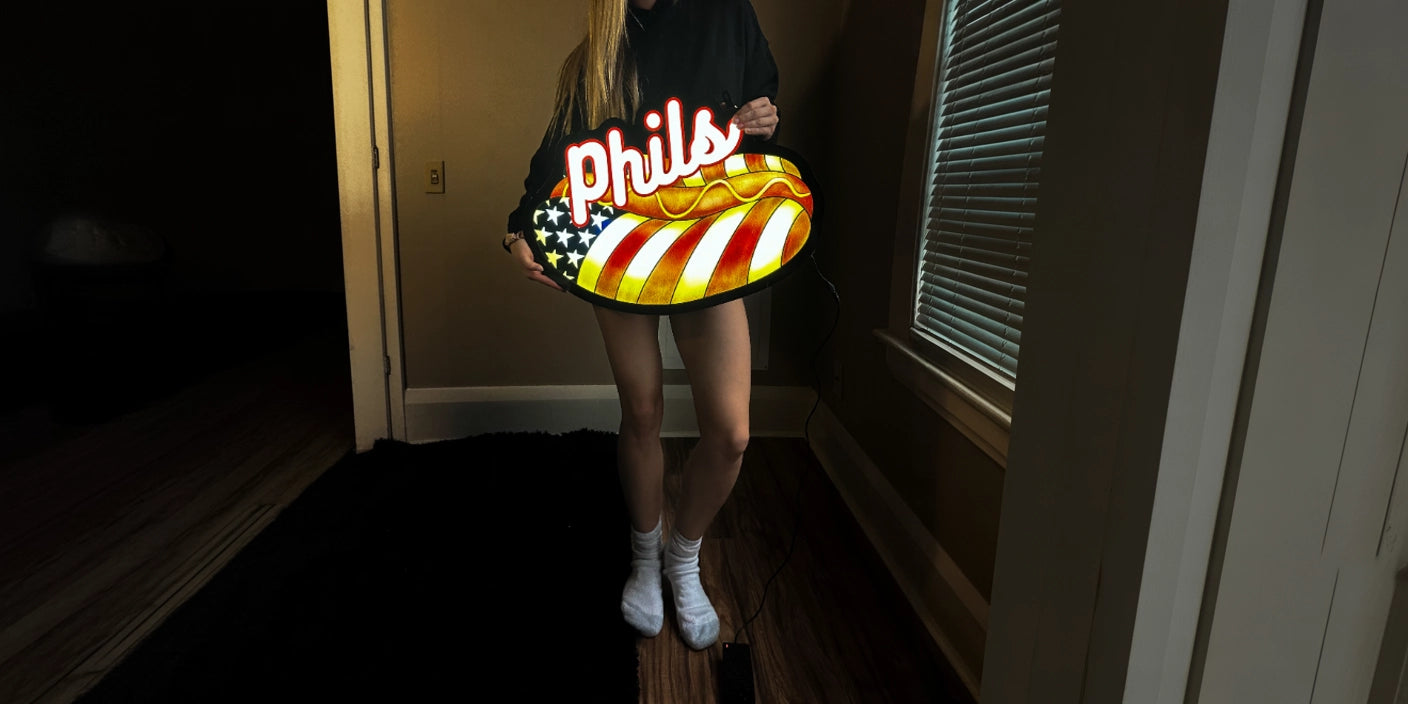 Woman holding Phils hot dog lightbox sign with American flag design