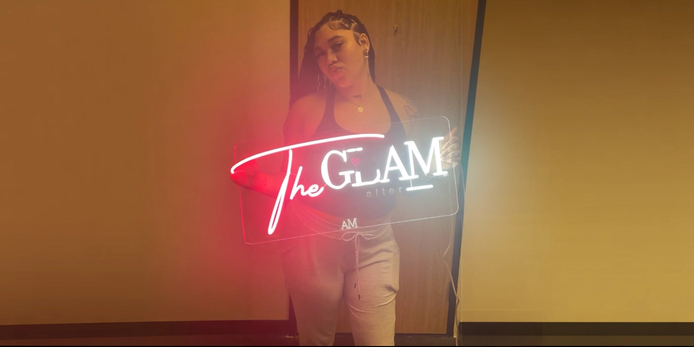 Woman holding The Glam neon sign in modern studio with brown wall background