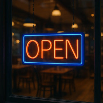Red and blue open neon sign hanging on glass door of restaurant at night