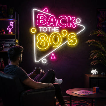 Back to the 80s neon sign glowing in pink, yellow, and white on a dark wall, creating a bold retro-inspired room atmosphere.