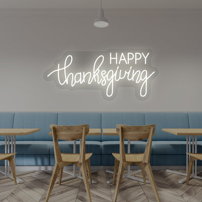 Happy Thanksgiving neon sign in white script on cafe wall