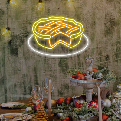 Thanksgiving pie neon sign with yellow and orange lattice design above festive holiday table with ornaments and candles