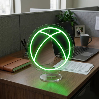 Green Xbox neon lamp on a modern office desk beside a laptop, notebook, and workspace essentials in a professional cubicle setting.