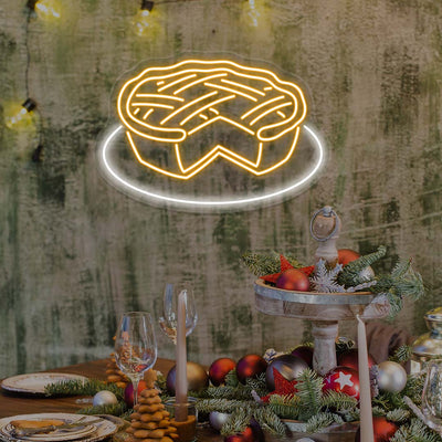 Thanksgiving pie neon sign in bright warm white above festive table with holiday ornaments and candles