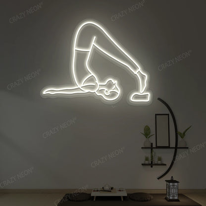 Halasana Yoga Neon Sign glowing in warm white color in a yoga room