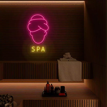 Serenity Face Spa neon sign in pink and yellow colors mounted in a spa room