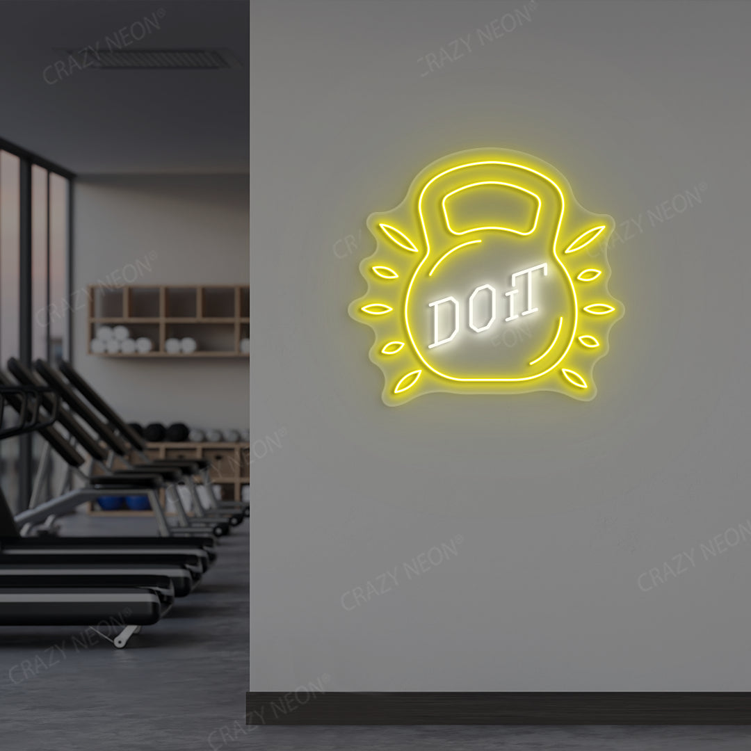 yellow and white do it kettlebell gym neon sign mounted on a wall