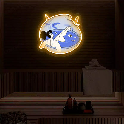 Blue Blossom Bath Neon Artwork lighting up in orange color on a wooden spa wall