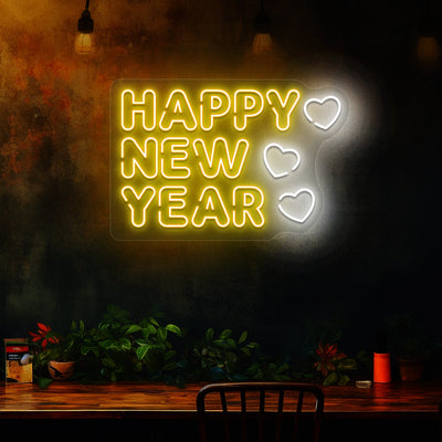 Happy New Year neon sign in yellow and white heart lights mounted on a dark wall 