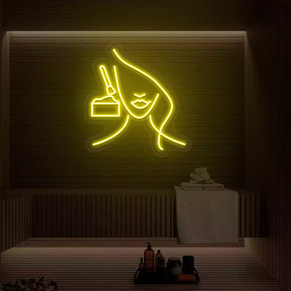 Yellow Facial Retreat neon sign glowing on a wooden wall