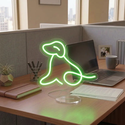 Green Dog Neon lamp on a modern office desk beside a laptop, notebook, and coffee mug, creating a warm and creative workspace atmosphere.