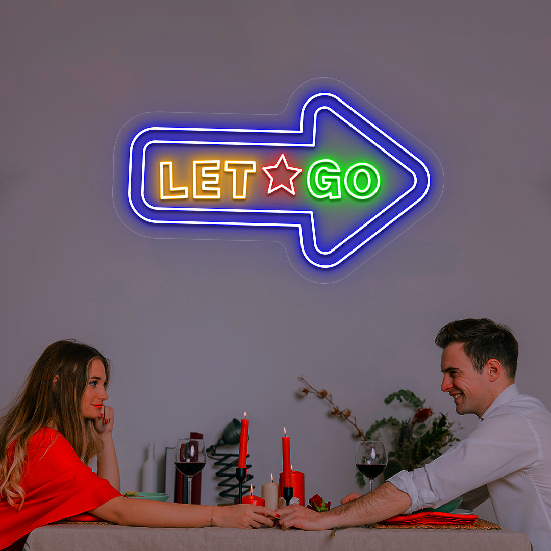 blue let go arrow vintage neon sign mounted on a wall