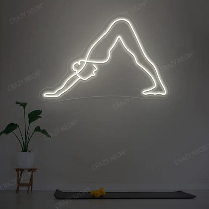 Adho Mukha Svanasana Yoga Neon Sign lighting up in warm white color in a yoga room