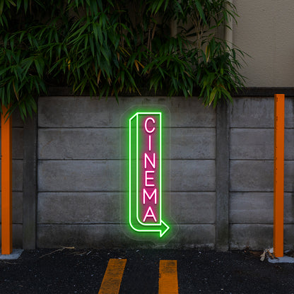 pink and green midnight cinema vintage neon sign mounted on a wall
