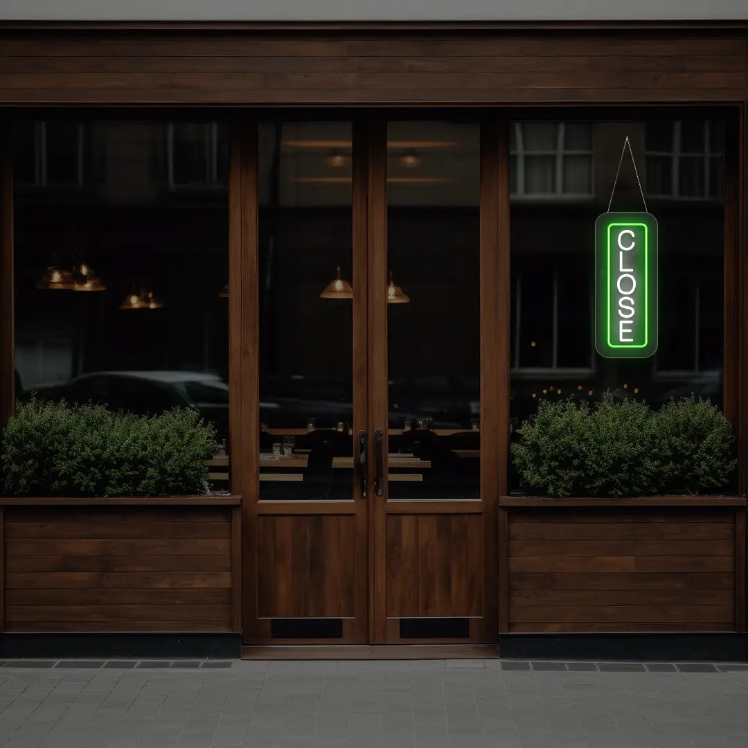 green vertical close neon sign hanging on a window