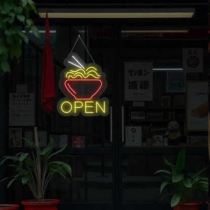 yellow noodles open neon sign hanging on a window