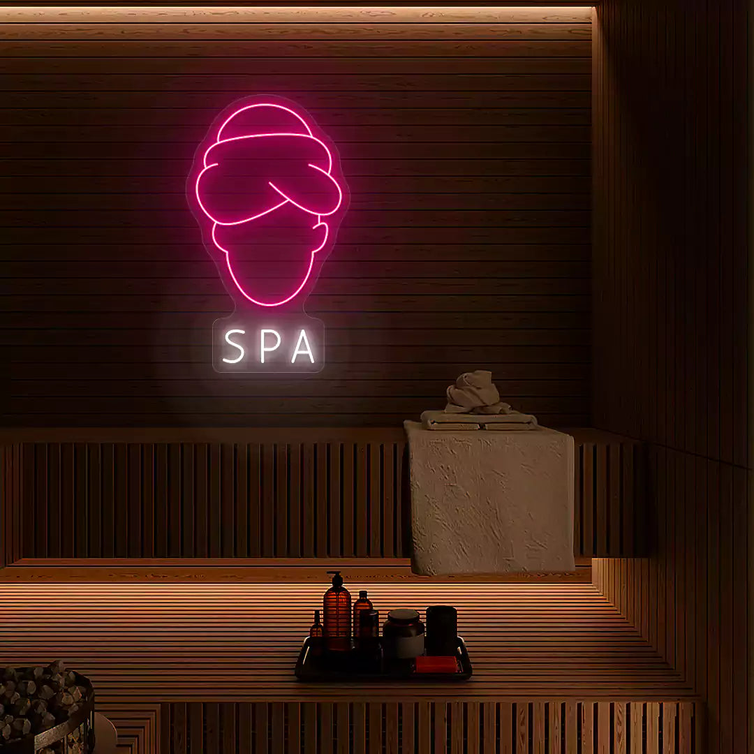 Serenity Face Spa neon sign in pink and white colors mounted in a spa room