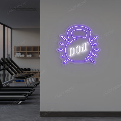 purple and white do it kettlebell gym neon sign mounted on a wall