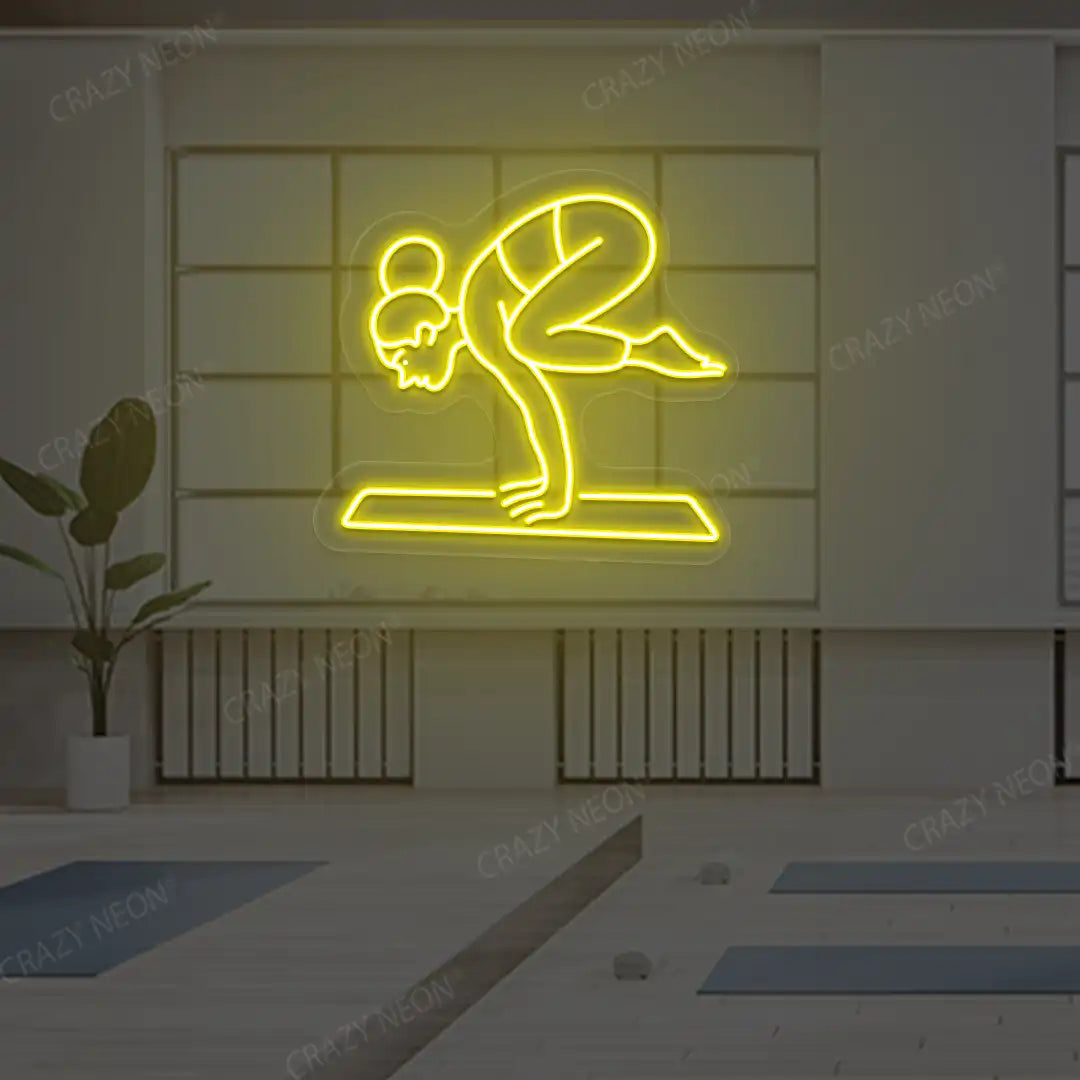Bakasana Yoga Neon Sign lighting up in yellow color in a yoga room