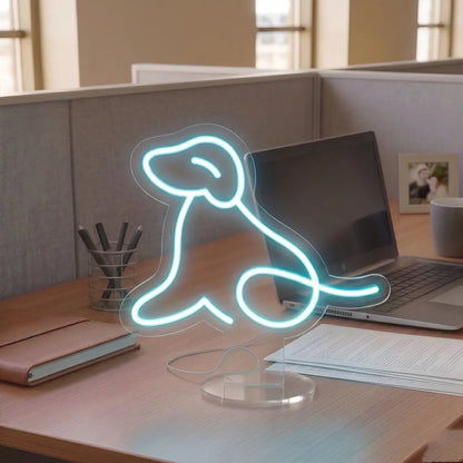 Ice Blue Dog Neon lamp on a modern office desk beside a laptop, notebook, and coffee mug, creating a warm and creative workspace atmosphere.