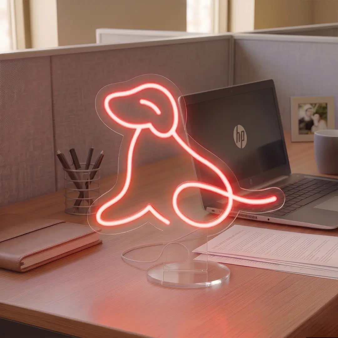 Red Dog Neon lamp on a modern office desk beside a laptop, notebook, and coffee mug, creating a warm and creative workspace atmosphere.