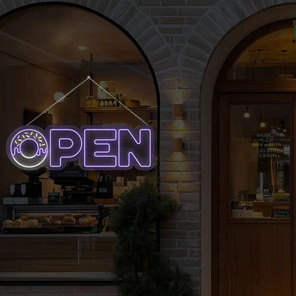 purple donut open neon sign hanging on a window