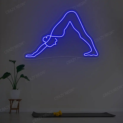 Adho Mukha Svanasana Yoga Neon Sign lighting up in blue color in a yoga room