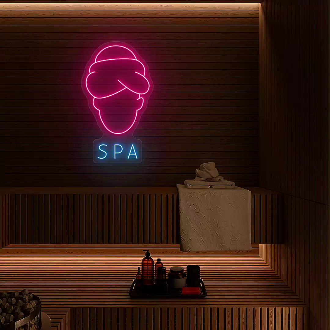 Serenity Face Spa neon sign in pink and ice blue colors mounted in a spa room