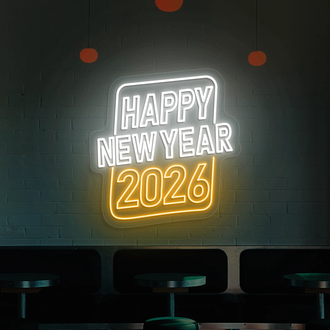 Neon sign reading Happy New Year 2026 in white and orange lights on a brick wall