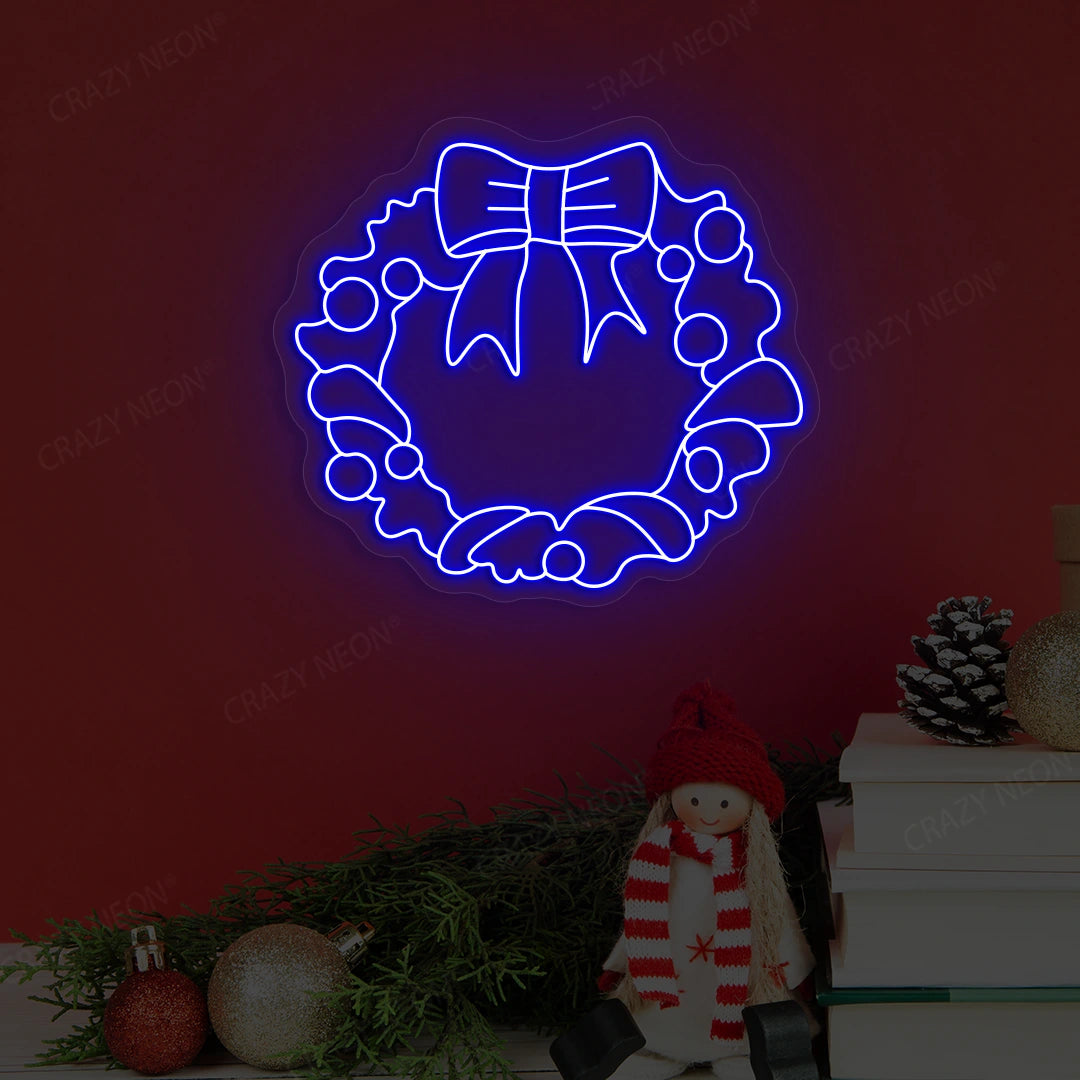 Blue neon holiday wreath artwork with bow, pine cones and festive decor