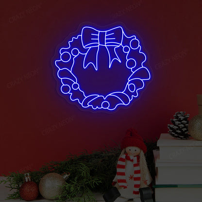 Blue neon holiday wreath artwork with bow, pine cones and festive decor