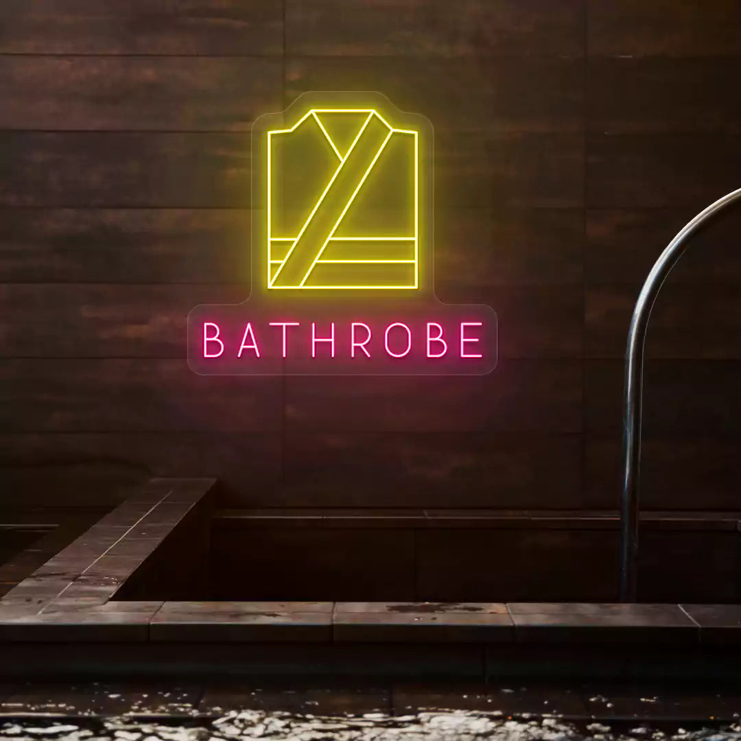Golden Bathrobe neon sign in yellow and pink colors glowing on a wooden wall