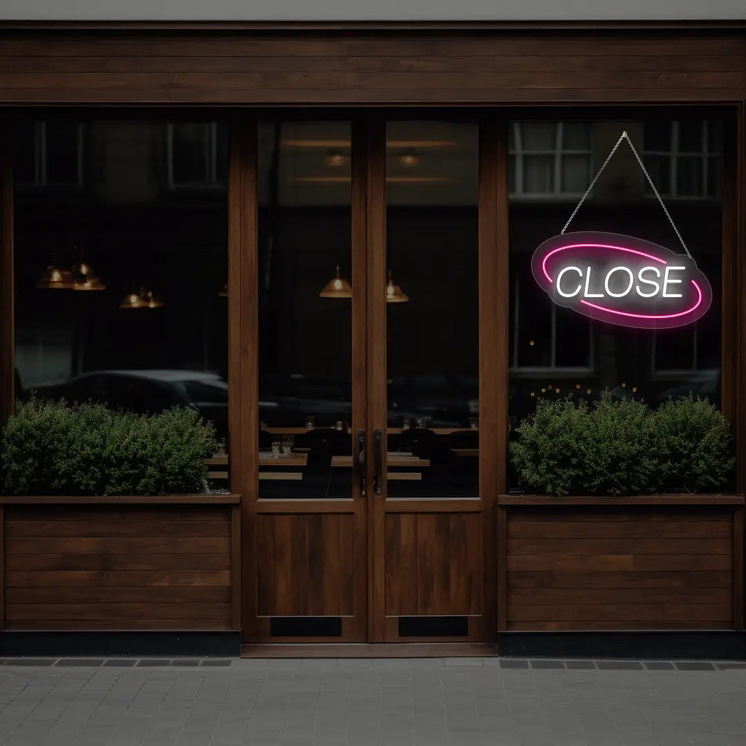 pink semi oval close neon sign hanging on a window