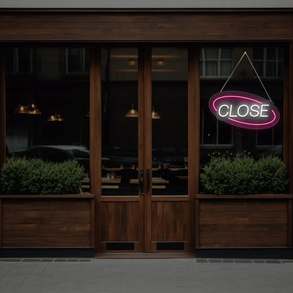 pink semi oval close neon sign hanging on a window