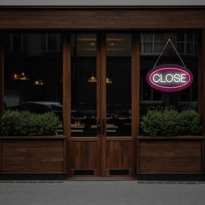 pink oval close neon sign hanging on a window